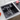 Black kitchen sink with faucet on a countertop with fruits