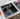 Black kitchen sink with faucet on a countertop with fruits